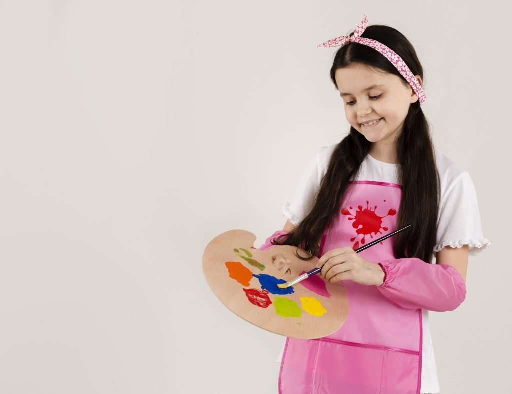 Child painting with bright colors, showing creativity and artistic expression for child growth.